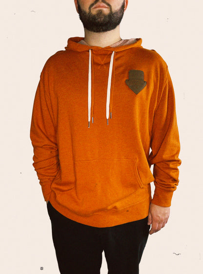 Burnt orange Independent Trading Company french terry hoodie embellished with a Wolf Den Wares branded leather patch