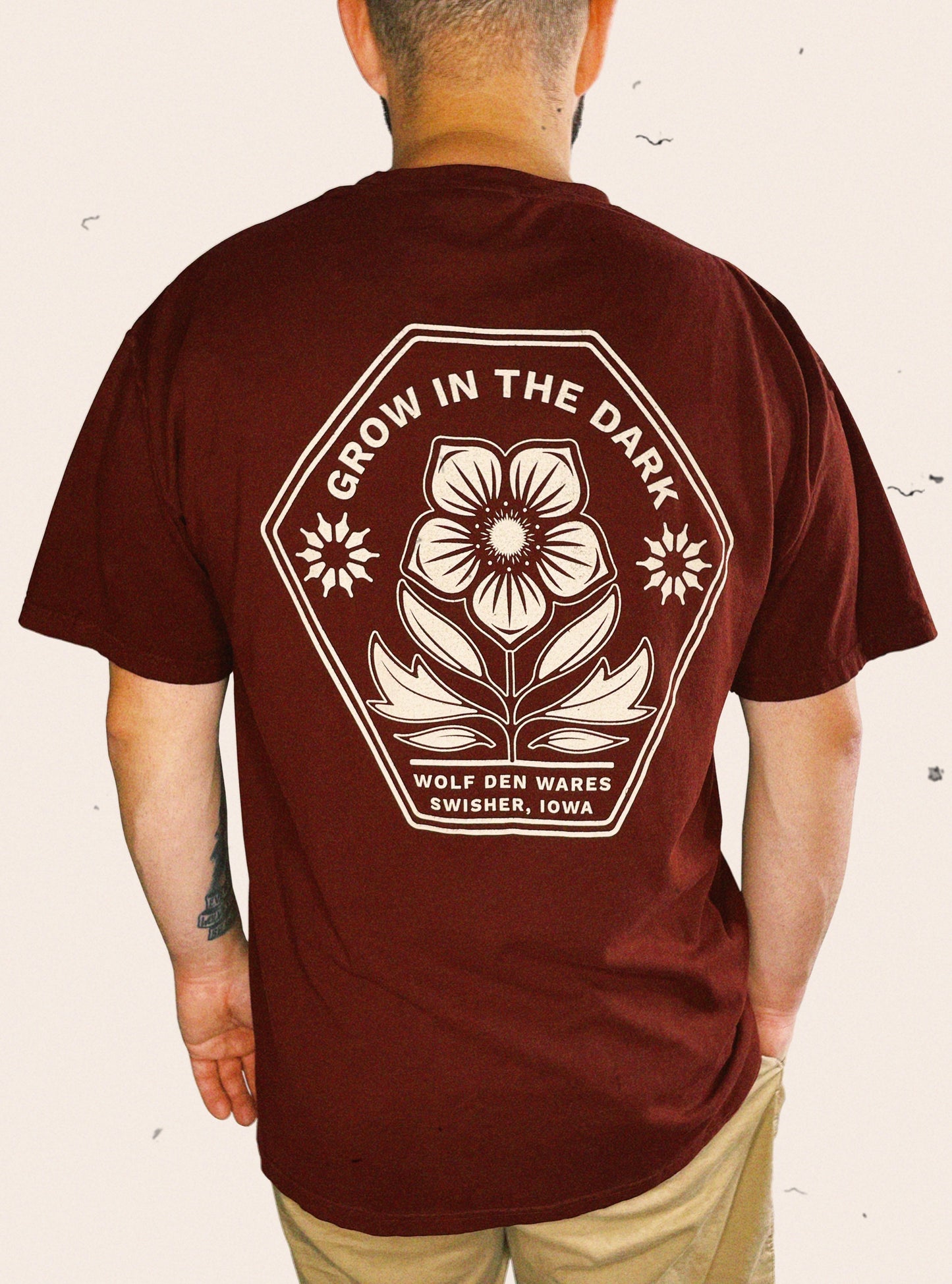 Maroon Comfort Colors tee embellished with a floral logo and the words GROW IN THE DARK, WOLF DEN WARES, and SWISHER, IOWA