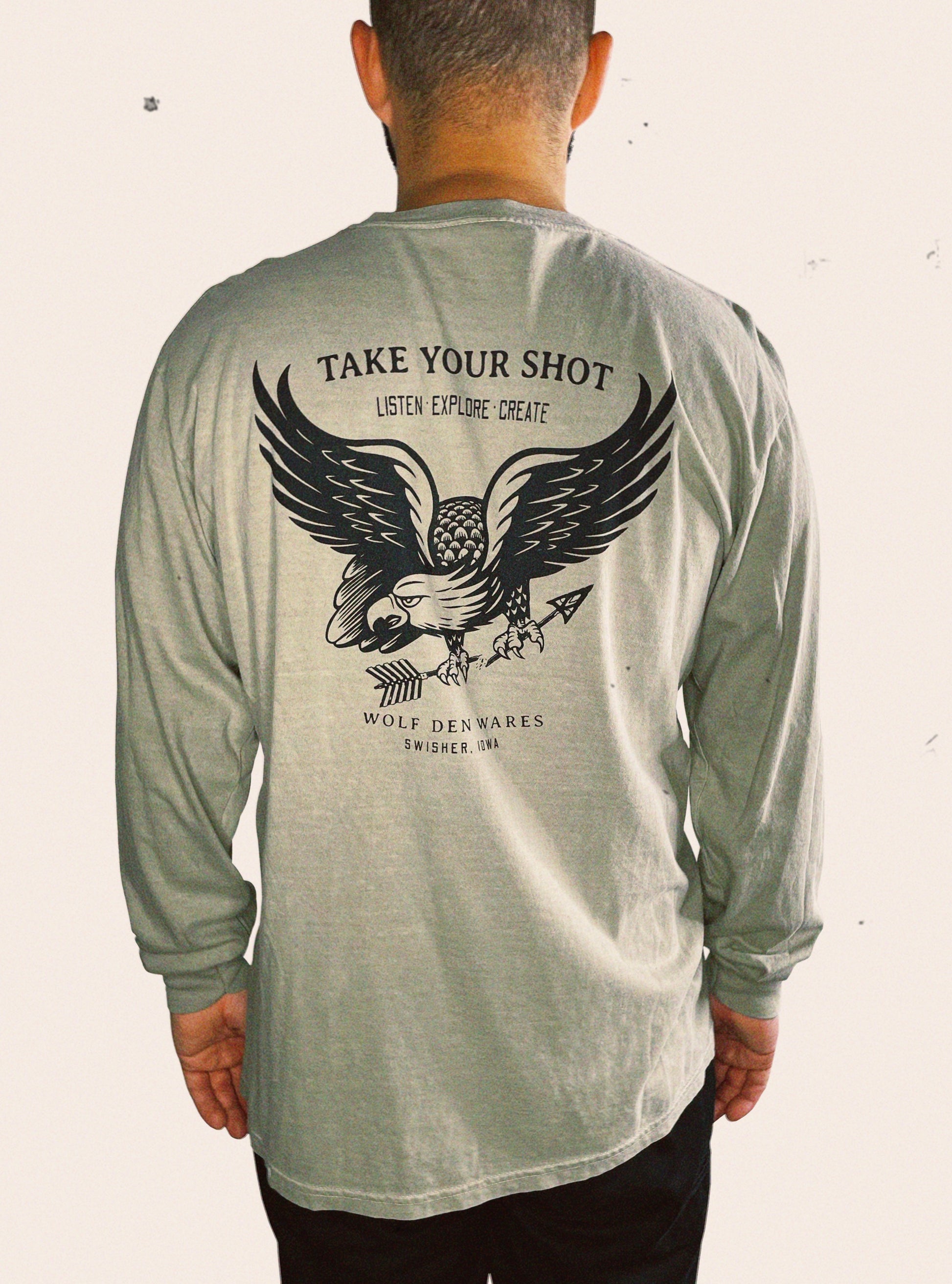 Sandstone Comfort Colors long sleeve embellished with an eagle and the words TAKE YOUR SHOT, LISTEN EXPLORE CREATE, WOLF DEN WARES, SWISHER, IOWA