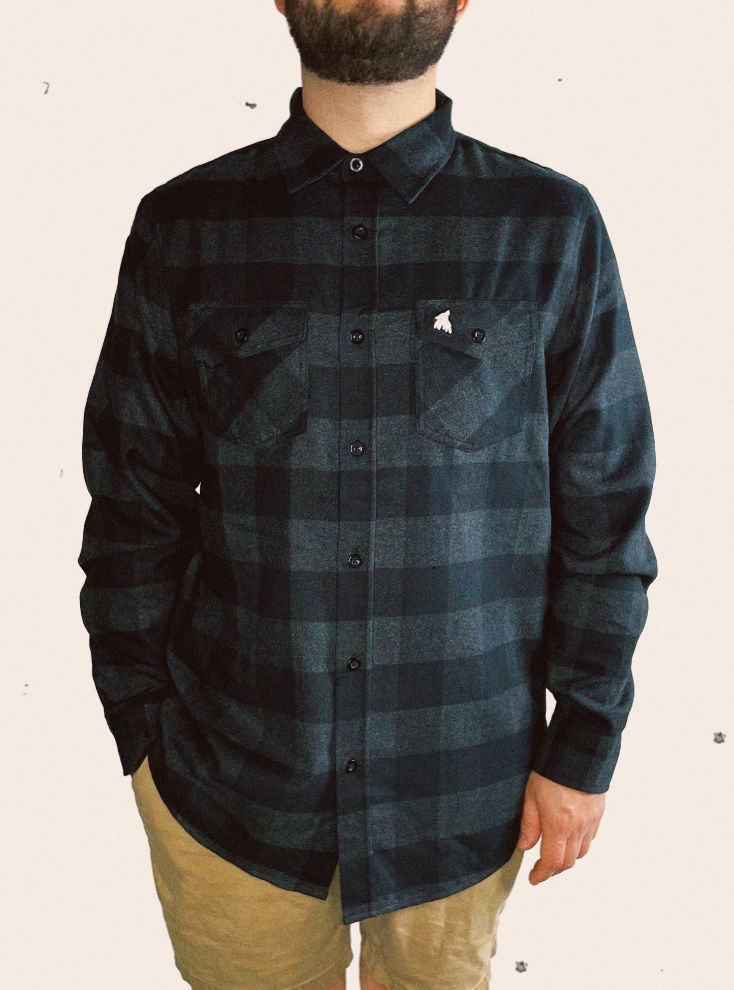 Charcoal heather and black Independent Trading Company plaid flannel embellished with a treeline wolf logo on the flap of the pocket
